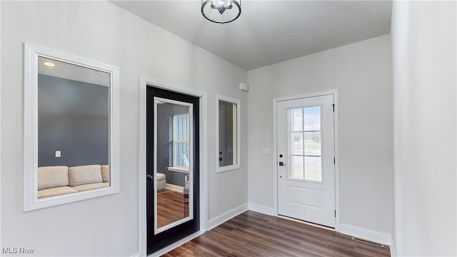 doorway to outside with visible vents, dark wood finished floors, and baseboards