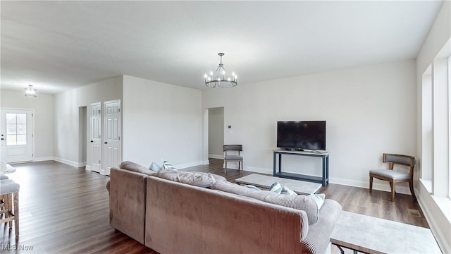 living area with dark wood-style floors, baseboards, and an inviting chandelier