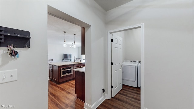 hall with a sink, baseboards, dark wood finished floors, and separate washer and dryer