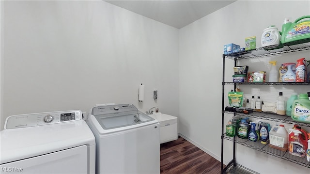 laundry area featuring laundry area, a sink, dark wood finished floors, baseboards, and washing machine and clothes dryer