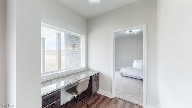 home office with baseboards, dark wood-style flooring, and built in study area