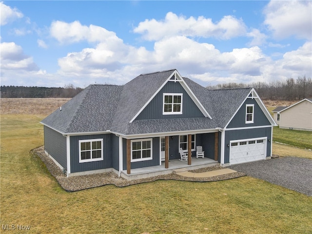 view of front facade featuring a front yard, covered porch, and driveway