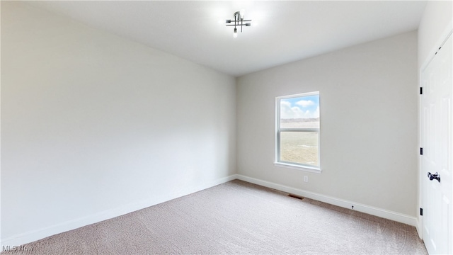 unfurnished room featuring carpet flooring, visible vents, and baseboards