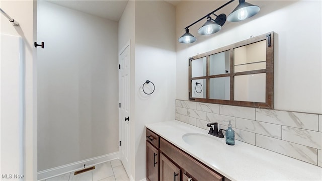 bathroom featuring tile patterned flooring, baseboards, decorative backsplash, and vanity