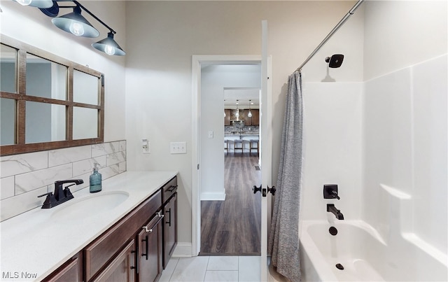 full bathroom featuring shower / bath combination with curtain, backsplash, and vanity