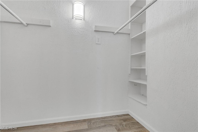 walk in closet featuring wood finished floors