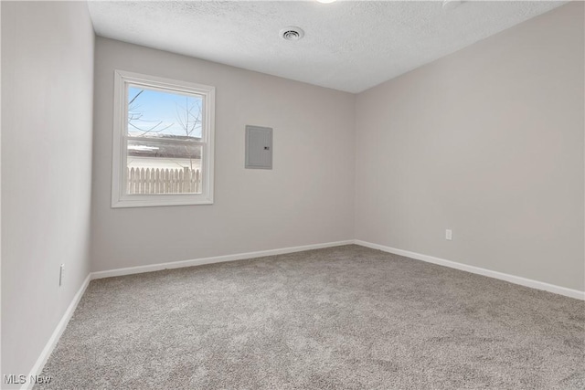 empty room featuring a textured ceiling, visible vents, baseboards, electric panel, and carpet