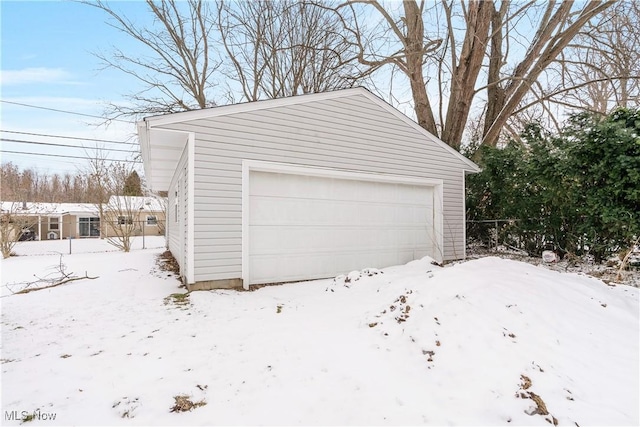 snow covered garage with a garage