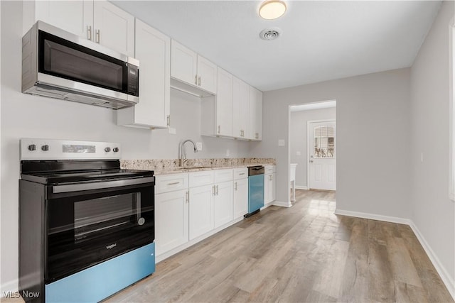 kitchen featuring light wood-style flooring, visible vents, white cabinetry, baseboards, and appliances with stainless steel finishes