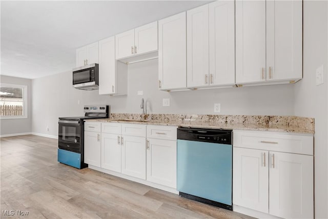 1893 Benjamin Rd, Madison, OH 44057 - kitchen featuring dishwashing machine, black range with electric stovetop, stainless steel microwave, light wood-style floors, and white cabinetry