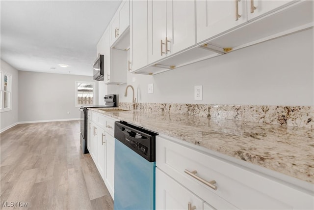 kitchen featuring appliances with stainless steel finishes, light wood-type flooring, white cabinets, and light stone countertops