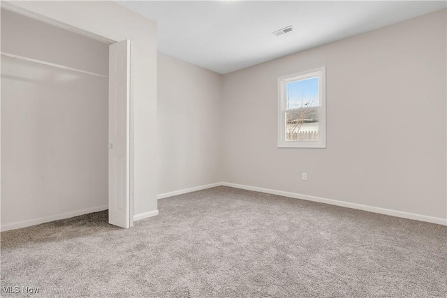 unfurnished bedroom with carpet, visible vents, baseboards, and a closet