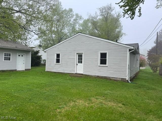 1893 Benjamin Rd, Madison, OH 44057 - rear view of house featuring a yard