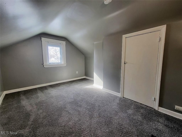 additional living space featuring carpet, vaulted ceiling, and baseboards