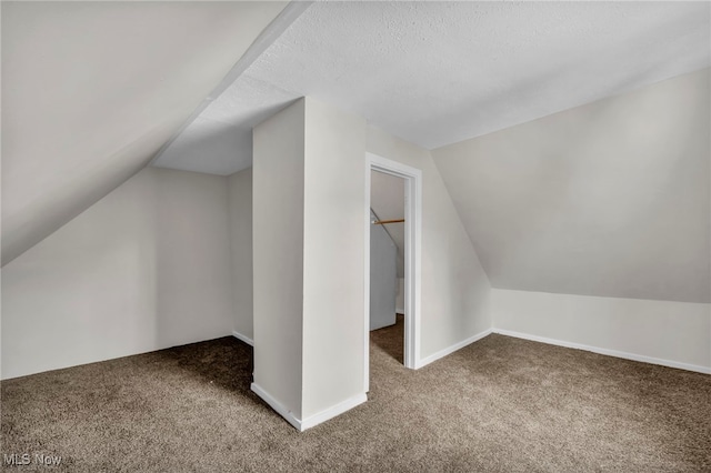 bonus room with carpet flooring, vaulted ceiling, a textured ceiling, and baseboards