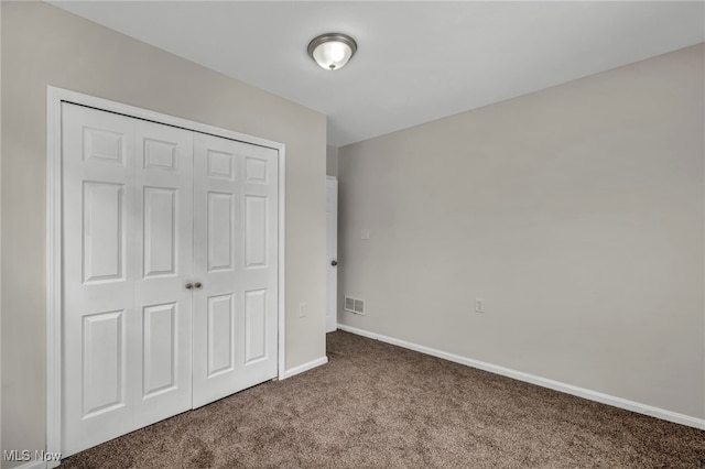 unfurnished bedroom with baseboards, a closet, visible vents, and carpet flooring