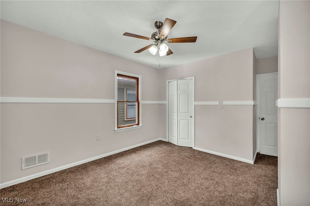 unfurnished room featuring ceiling fan, carpet floors, visible vents, and baseboards