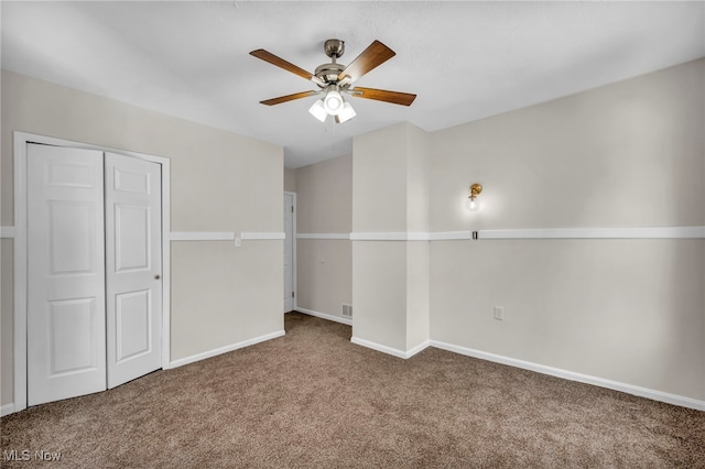 unfurnished bedroom featuring a ceiling fan, carpet, a closet, and baseboards