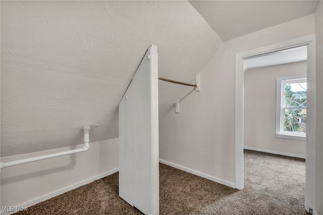 interior space featuring vaulted ceiling and carpet flooring