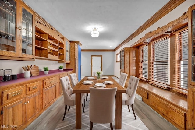 dining room featuring light wood-style floors and crown molding