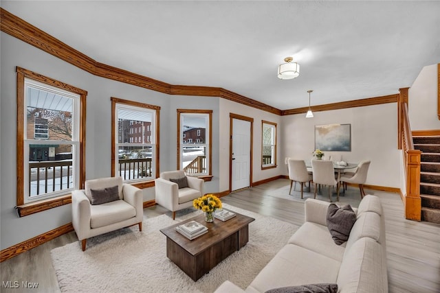 living room featuring baseboards, stairway, wood finished floors, and crown molding