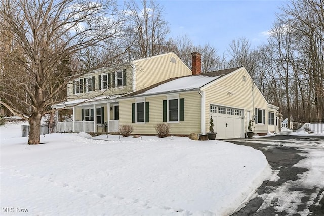 exterior space with a garage, a porch, and a chimney