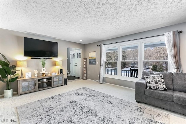 living room with a textured ceiling, baseboards, and carpet flooring