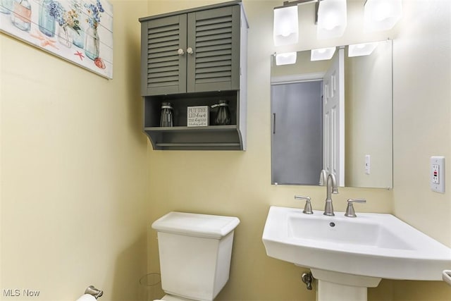 half bathroom featuring toilet and a sink