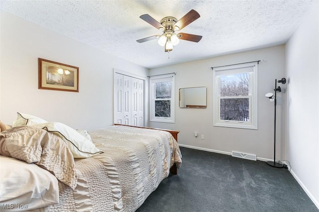 bedroom with dark colored carpet, visible vents, a textured ceiling, and baseboards