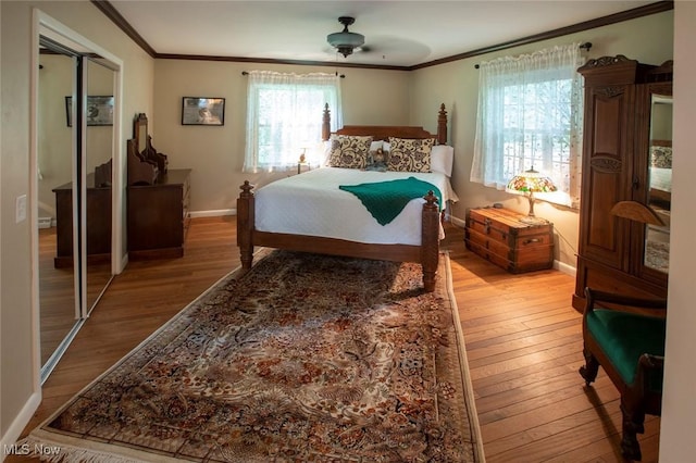 bedroom featuring ornamental molding, a ceiling fan, baseboards, and wood finished floors