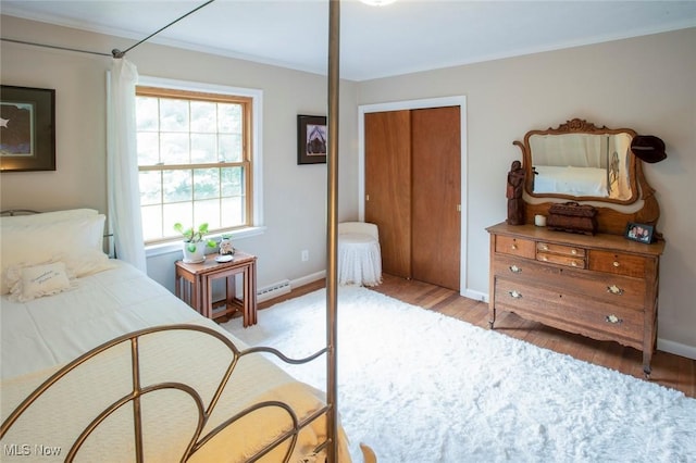 bedroom with light wood finished floors, baseboards, and a closet