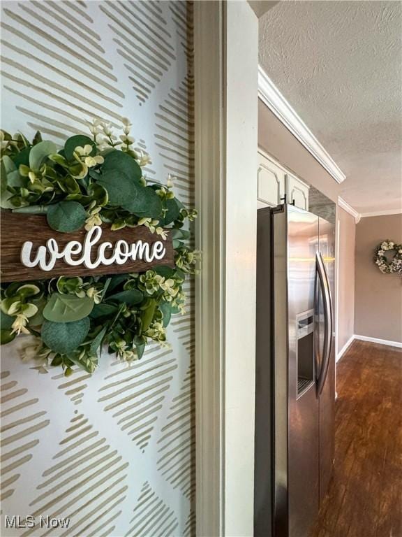 details with a textured ceiling, dark wood-type flooring, white cabinetry, stainless steel refrigerator with ice dispenser, and crown molding