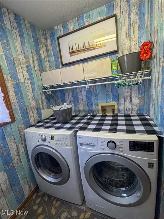 laundry room with laundry area, a textured ceiling, and separate washer and dryer