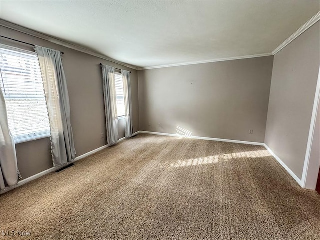 carpeted empty room featuring ornamental molding, visible vents, and baseboards