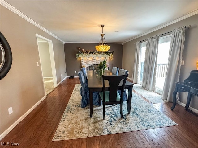 dining area featuring wood-type flooring, baseboards, and ornamental molding