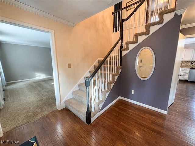 stairway with ornamental molding, hardwood / wood-style flooring, and baseboards