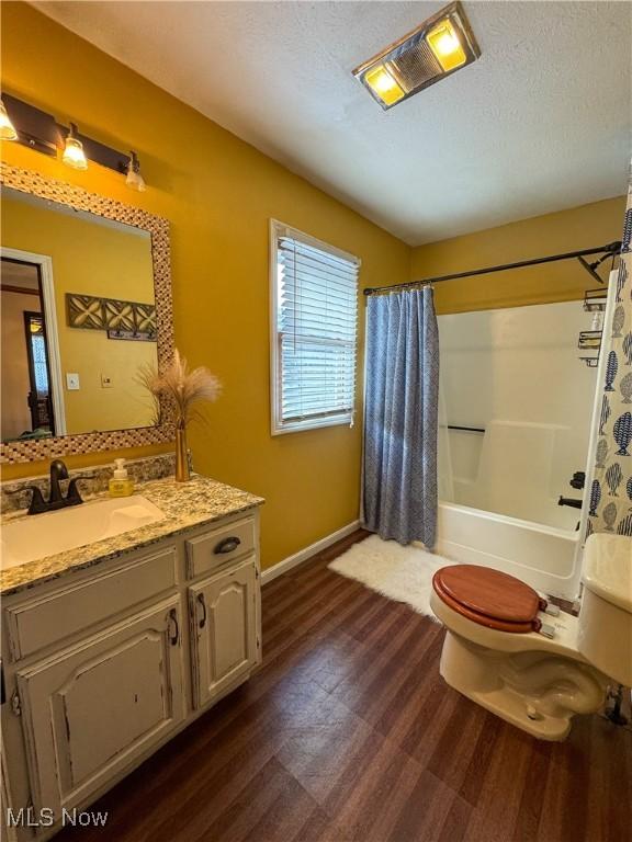 full bathroom featuring shower / bath combo, toilet, wood finished floors, a textured ceiling, and vanity