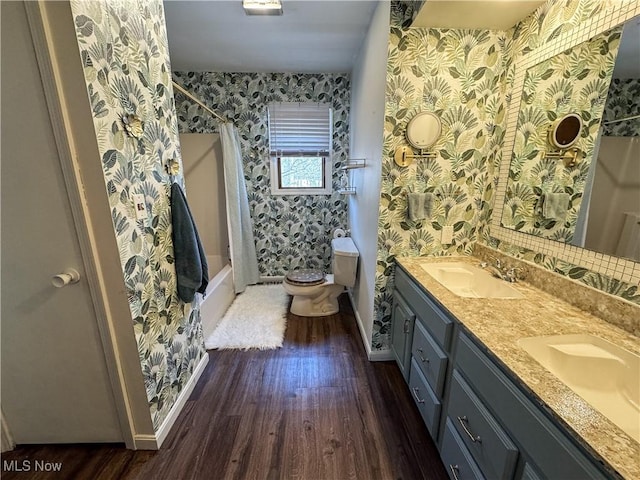 full bath featuring toilet, a sink, wood finished floors, a shower with curtain, and wallpapered walls