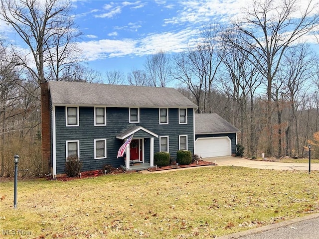 colonial home featuring a garage, a front yard, concrete driveway, and roof with shingles