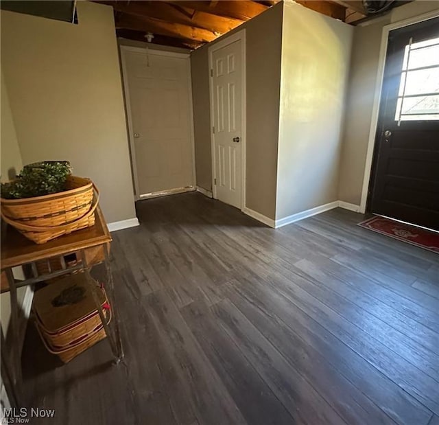 entryway with dark wood-type flooring and baseboards