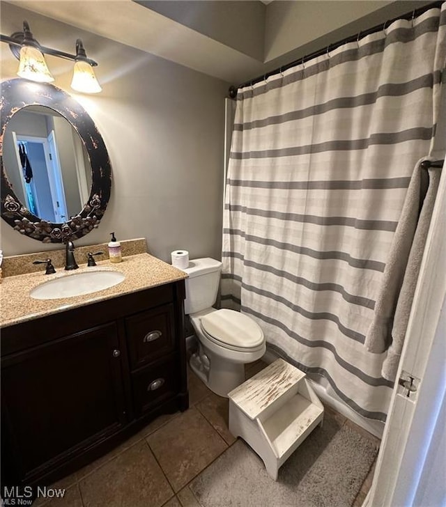 full bathroom with toilet, vanity, and tile patterned floors