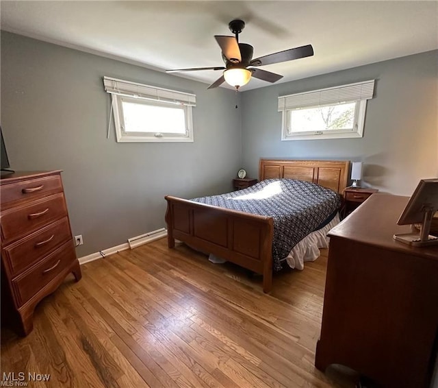 bedroom with a ceiling fan, baseboards, and wood finished floors