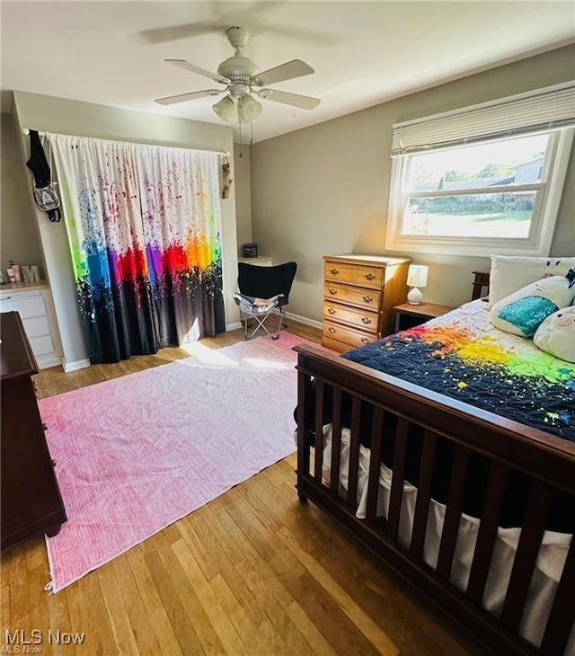 bedroom featuring ceiling fan, hardwood / wood-style floors, and baseboards