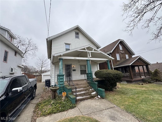 view of front facade with an outdoor structure, a porch, and a front yard