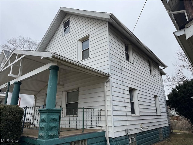 view of side of home featuring covered porch