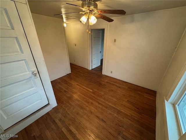 spare room featuring dark wood-type flooring and ceiling fan