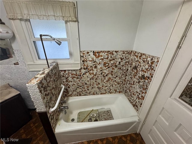 full bath featuring tile walls, vanity, and a bathing tub