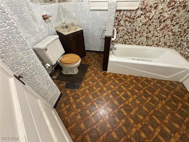 full bathroom featuring toilet, a bathing tub, and vanity