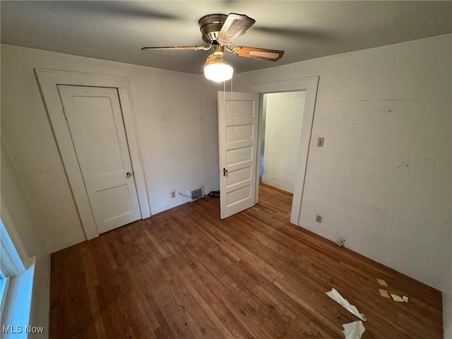 unfurnished bedroom featuring ceiling fan, wood finished floors, and visible vents