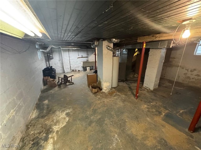 unfinished below grade area featuring water heater and wooden ceiling